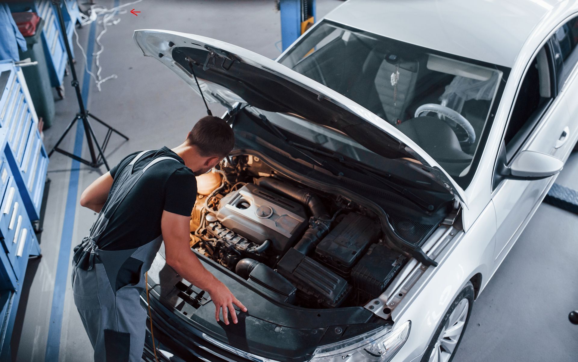 a man is looking under the hood of a car