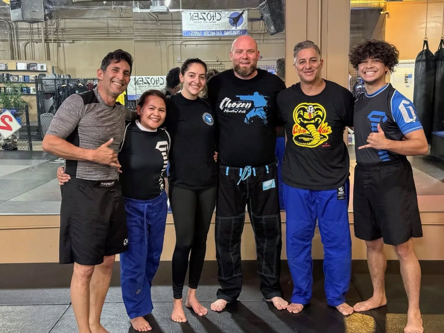 two men in blue and white kimonos are wrestling on a mat