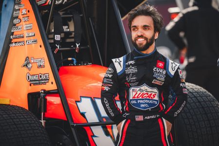 Rico Abreu standing in front of a race car.