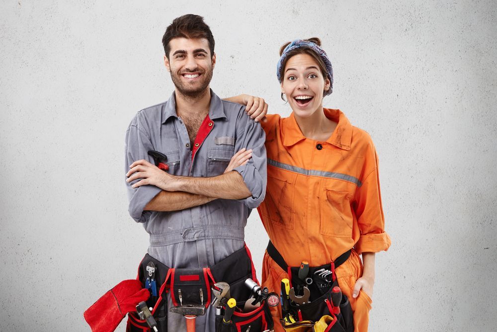 A Man And A Woman Are Standing Next To Each Other — H2O Plumbing & Maintenance Services In Armidale, NSW