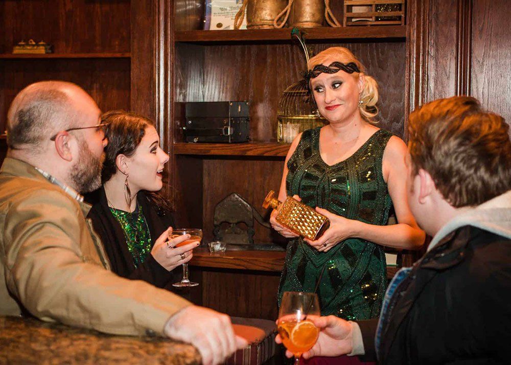waitress in green dress serving a party of three at a bar
