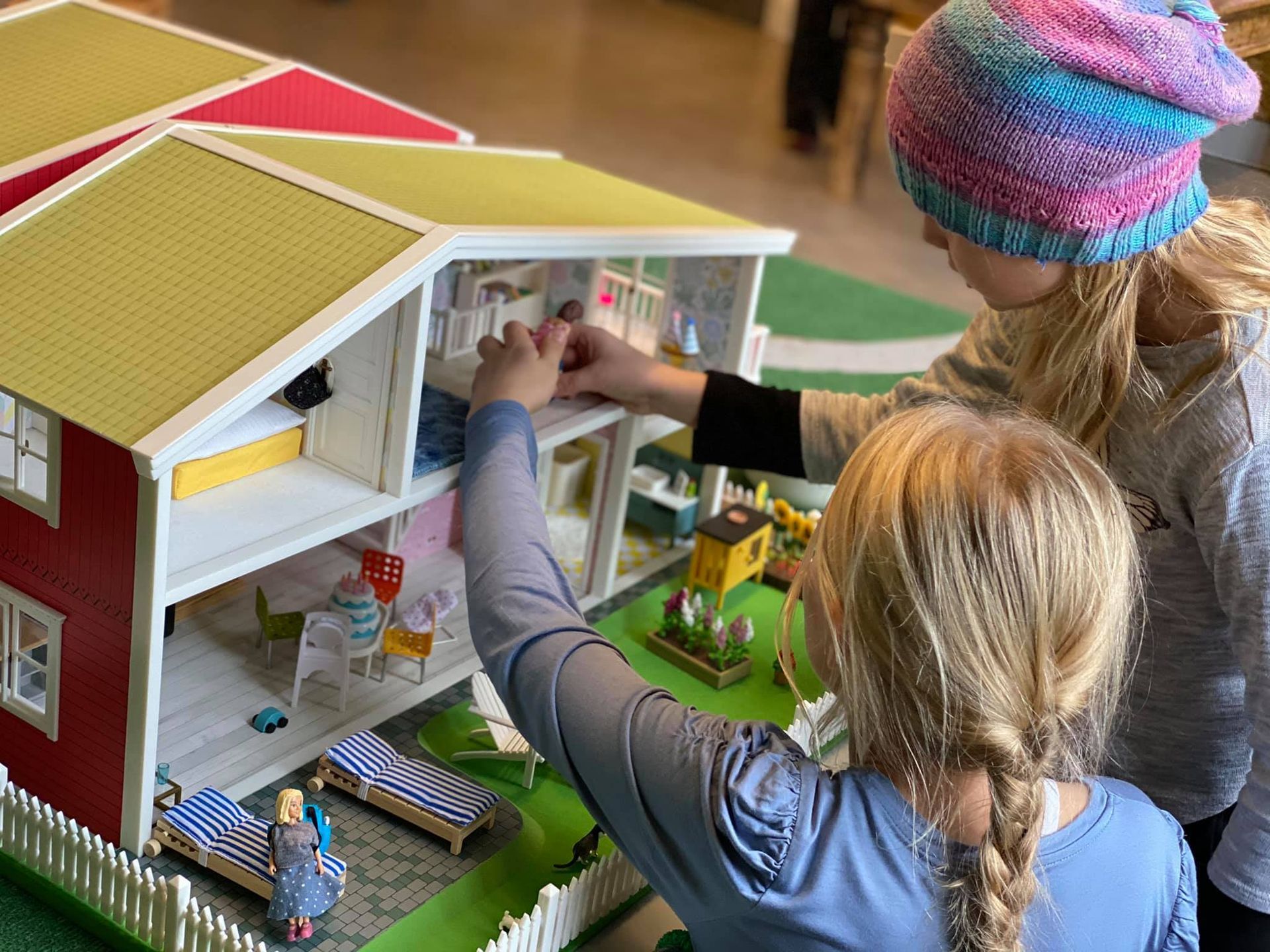 To unge drenge sidder ved et træbord og skriver på et stykke papir.