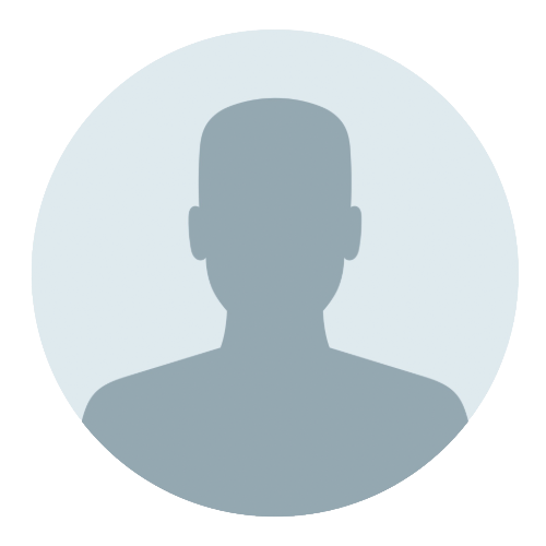 En skaldet mand står foran en hvid væg med armene over kors.