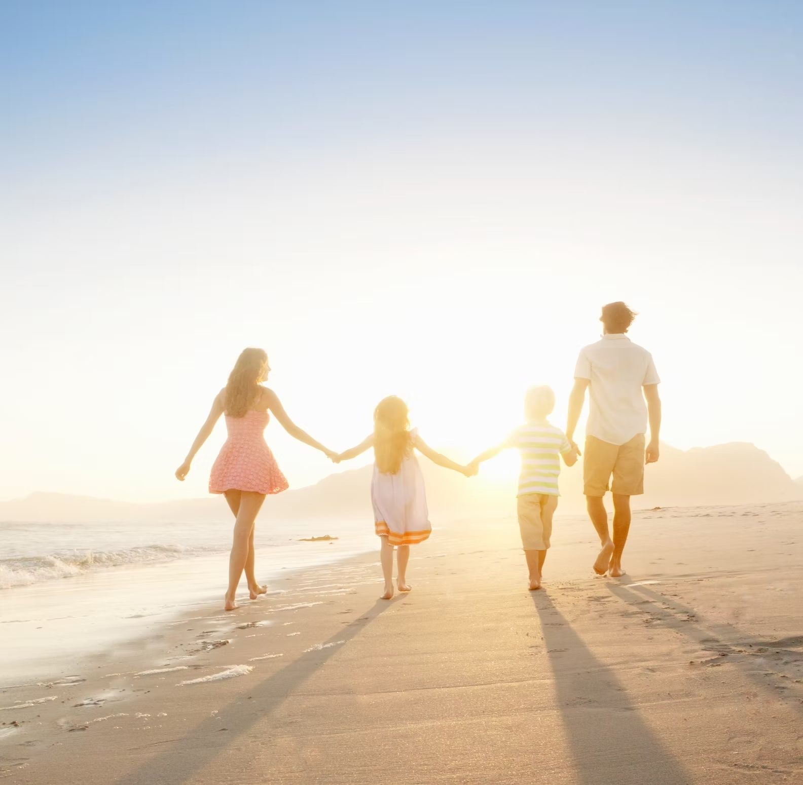 A Family is Walking on the Beach Holding Hands — Pollock Ingram Solicitors in Caloundra, QLD