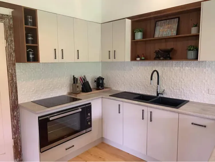 A Kitchen With White Cabinets and a Black Stove Top Oven — Moore Than Just Kitchens In Manilla, NSW
