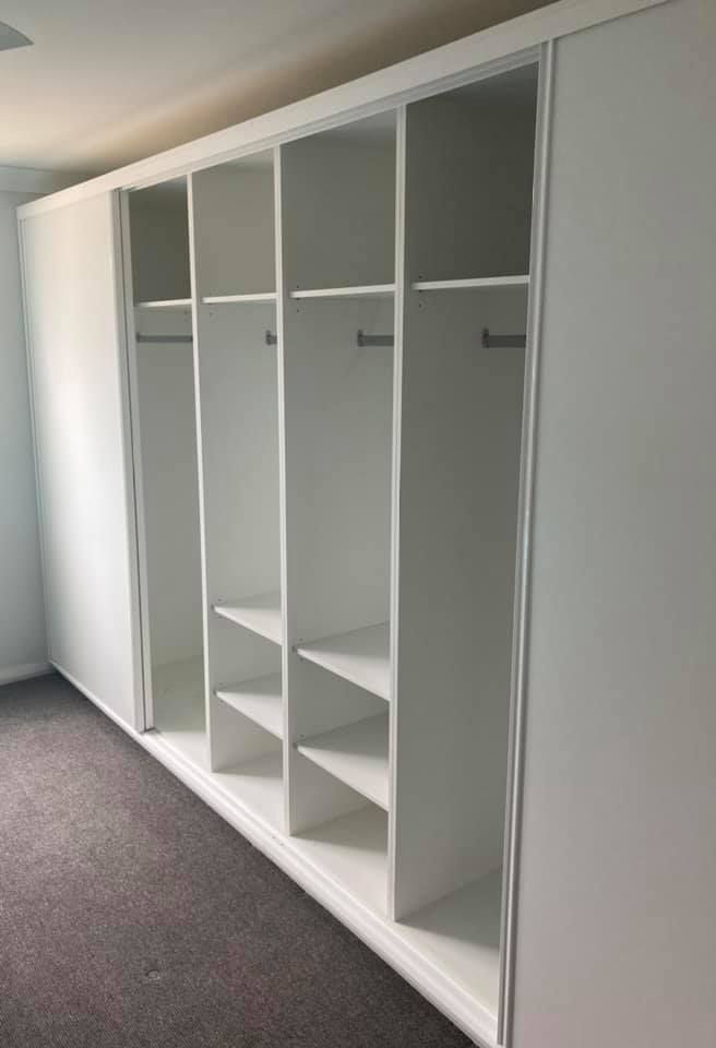 A Large White Wardrobe With Sliding Doors and Shelves in a Bedroom — Moore Than Just Kitchens In Manilla, NSW