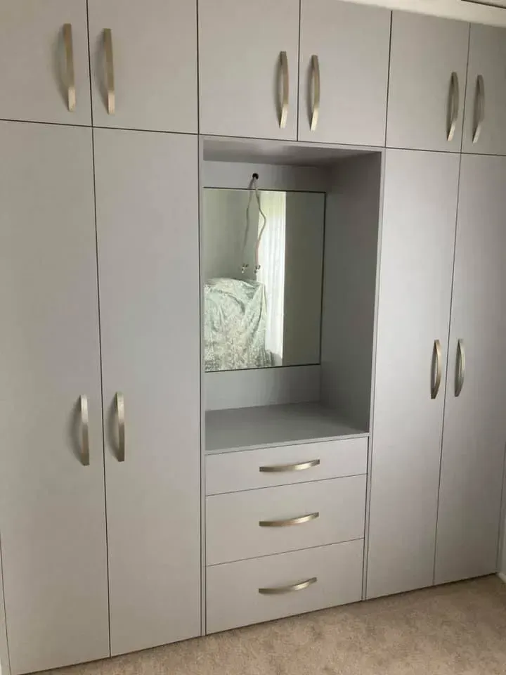 A Large White Wardrobe With a Mirror and Drawers in a Bedroom — Moore Than Just Kitchens In Manilla, NSW