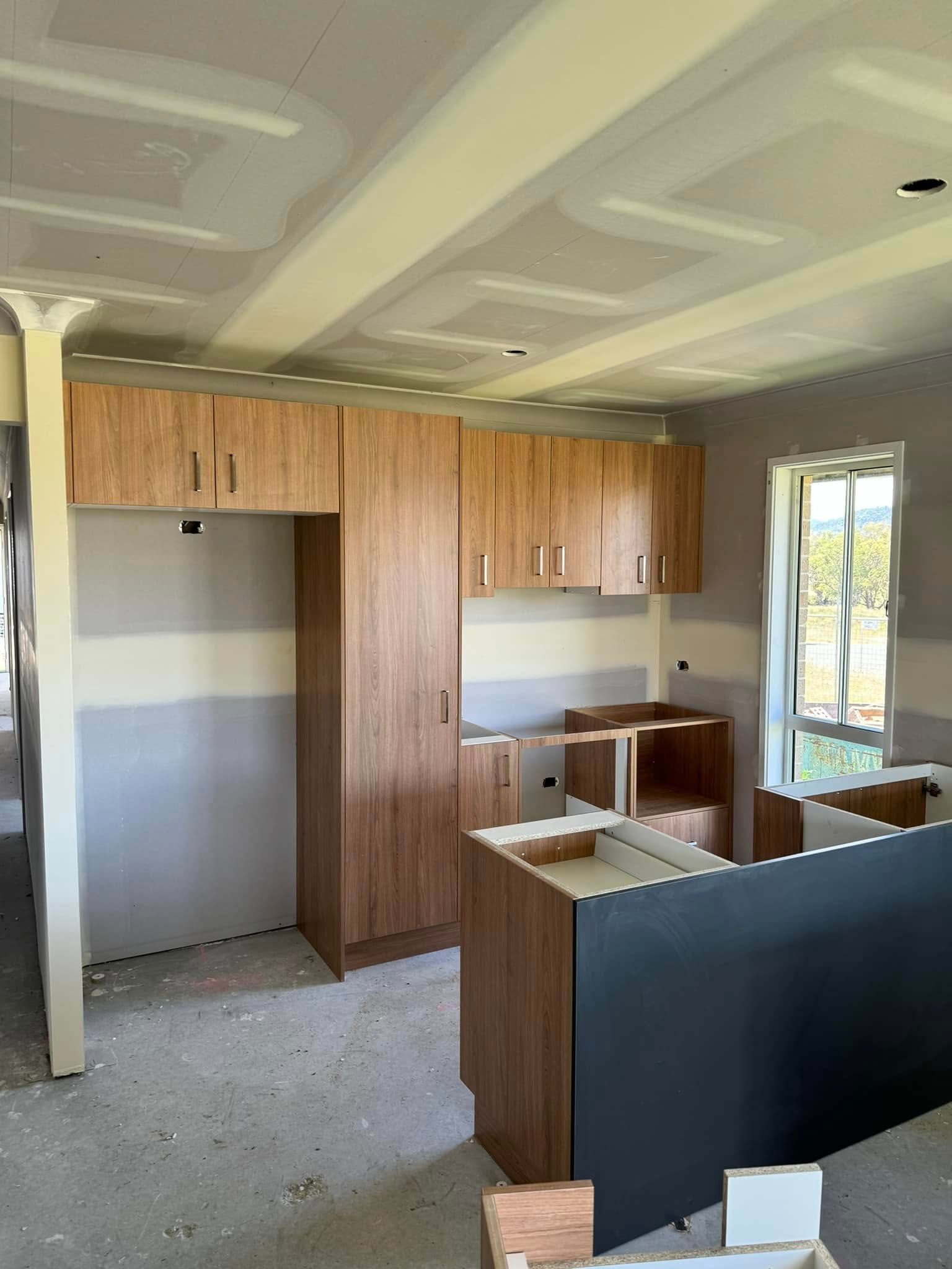 A Kitchen Under Construction With Wooden Cabinets and a Window — Moore Than Just Kitchens In Tamworth, NSW