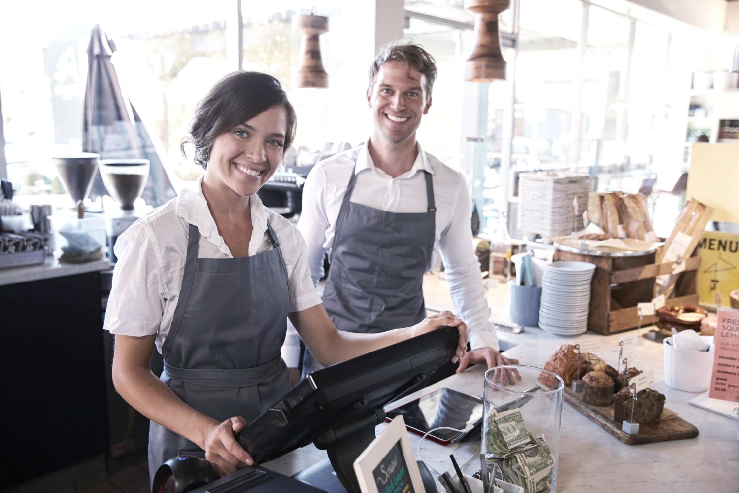 Employees at a local market smile by the cash register