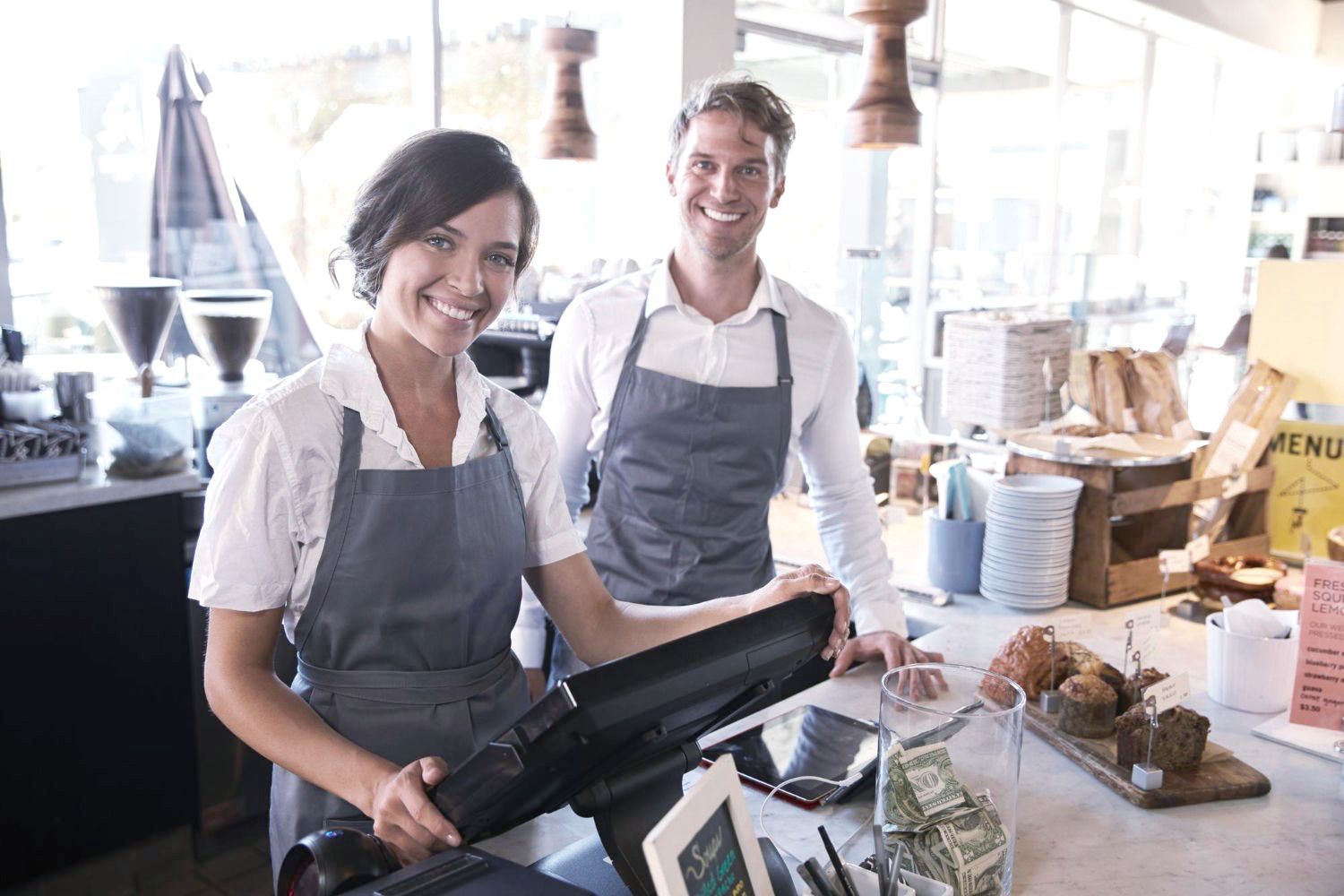 Employees at a local market smile by the cash register