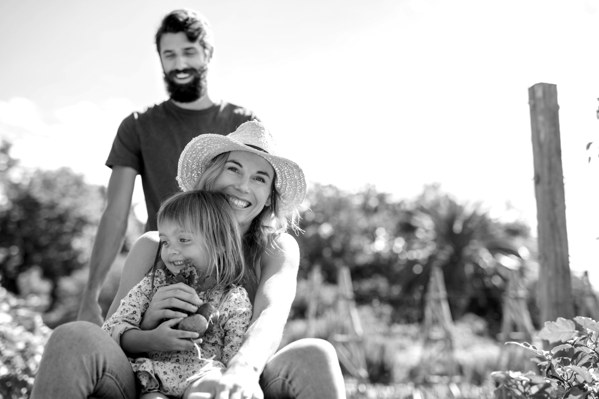 A black and white photo of a family sitting in a garden.