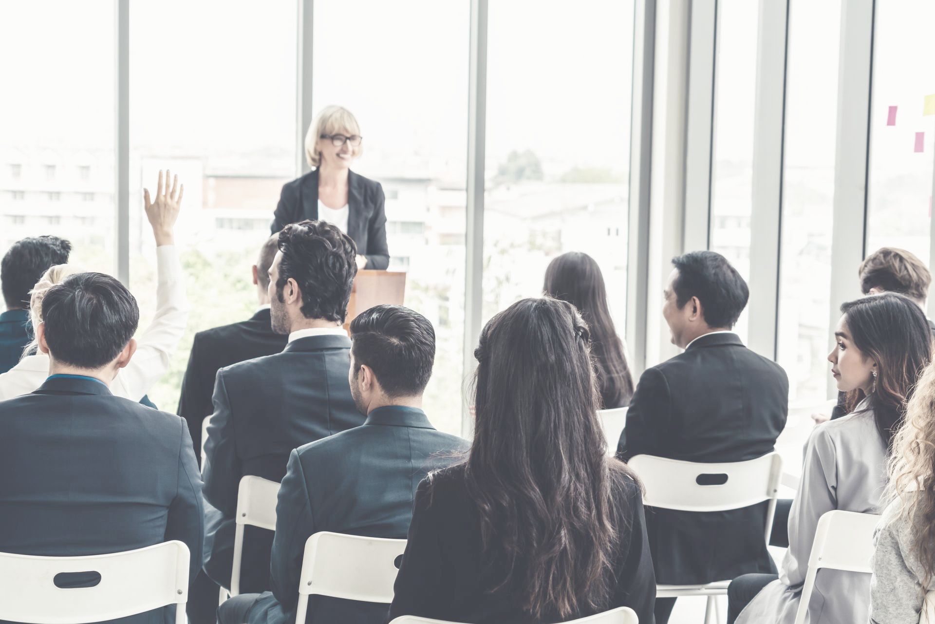 A woman is giving a presentation to a group of employees in a conference room.