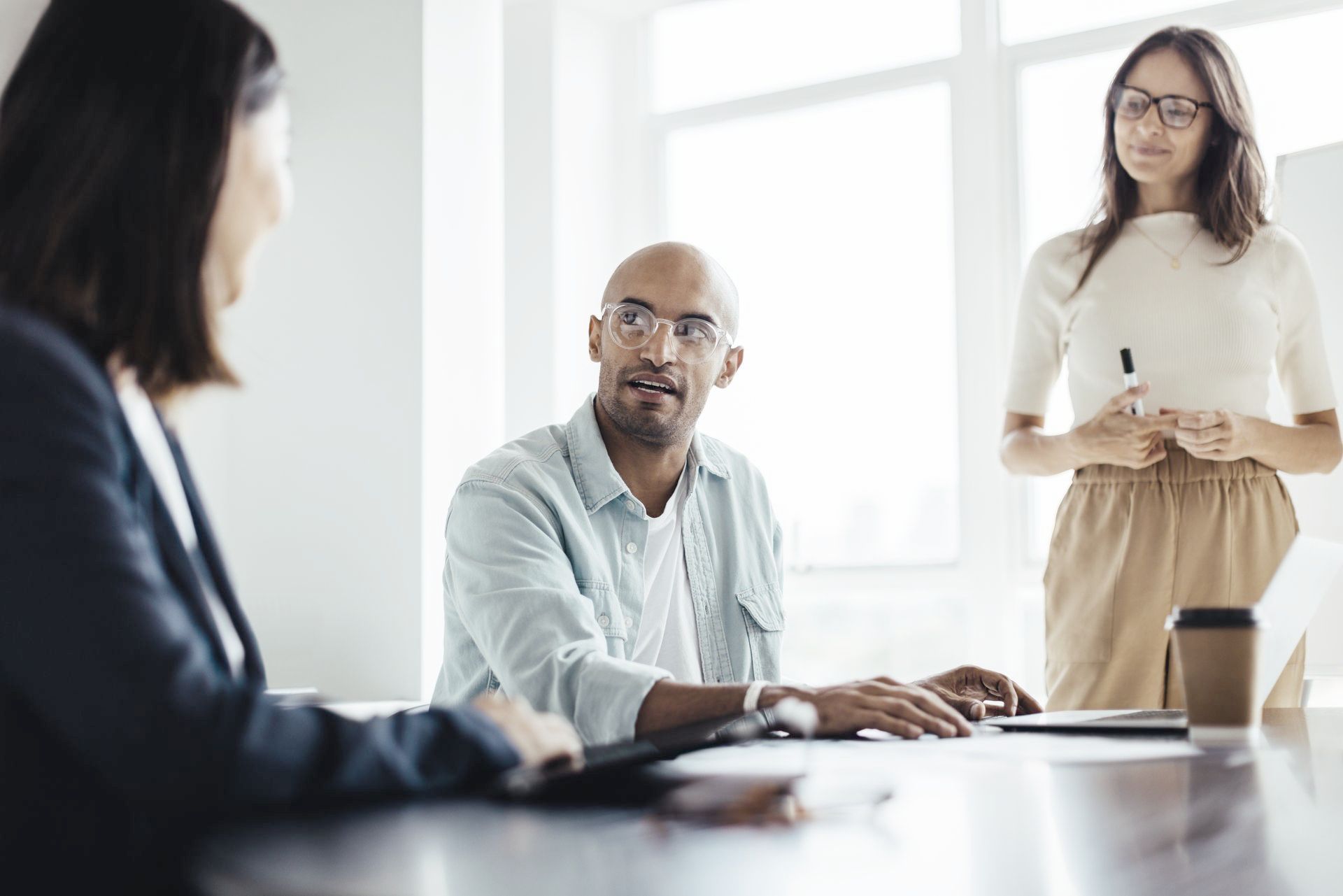 A group of people are sitting around a table having a meeting.