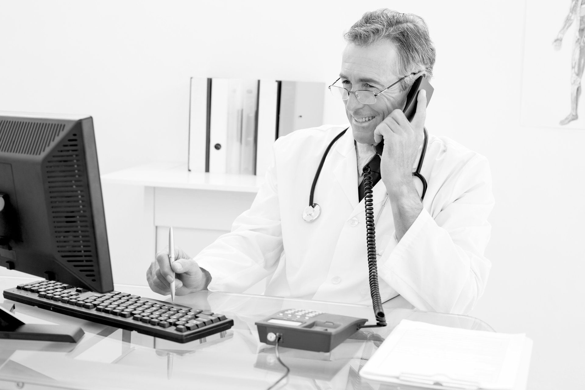 a doctor is sitting at a desk talking on a phone