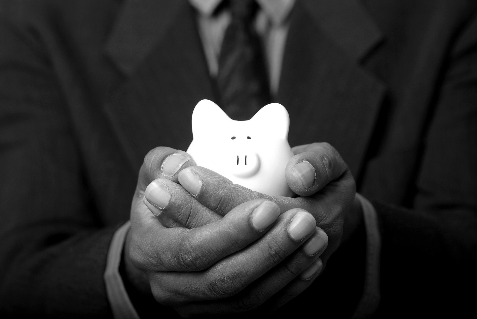 a man in a suit is holding a piggy bank in his hands