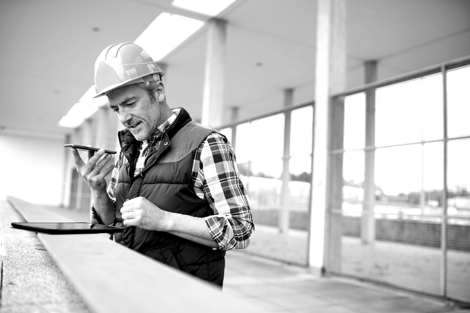 a man wearing a hard hat is talking on a cell phone