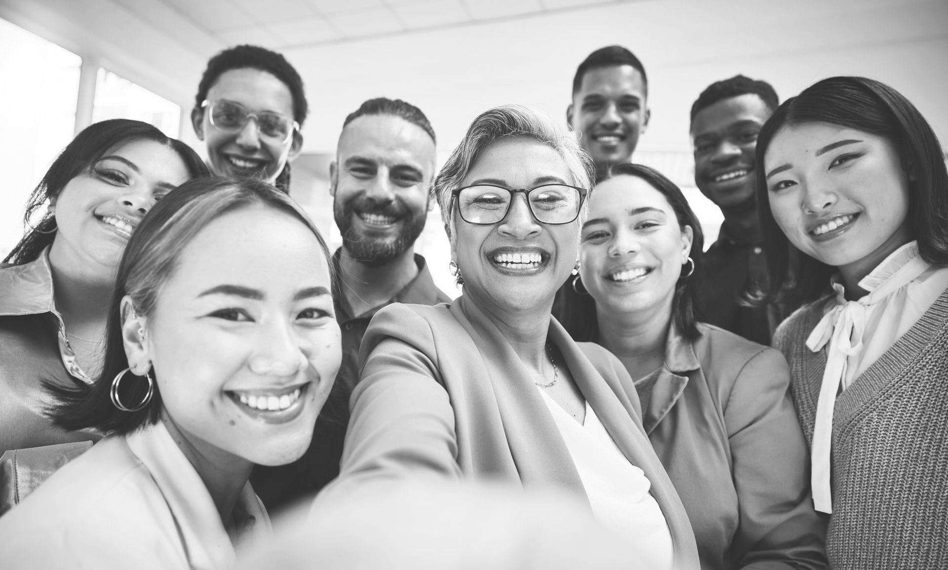 A group of people are taking a selfie together in a black and white photo.