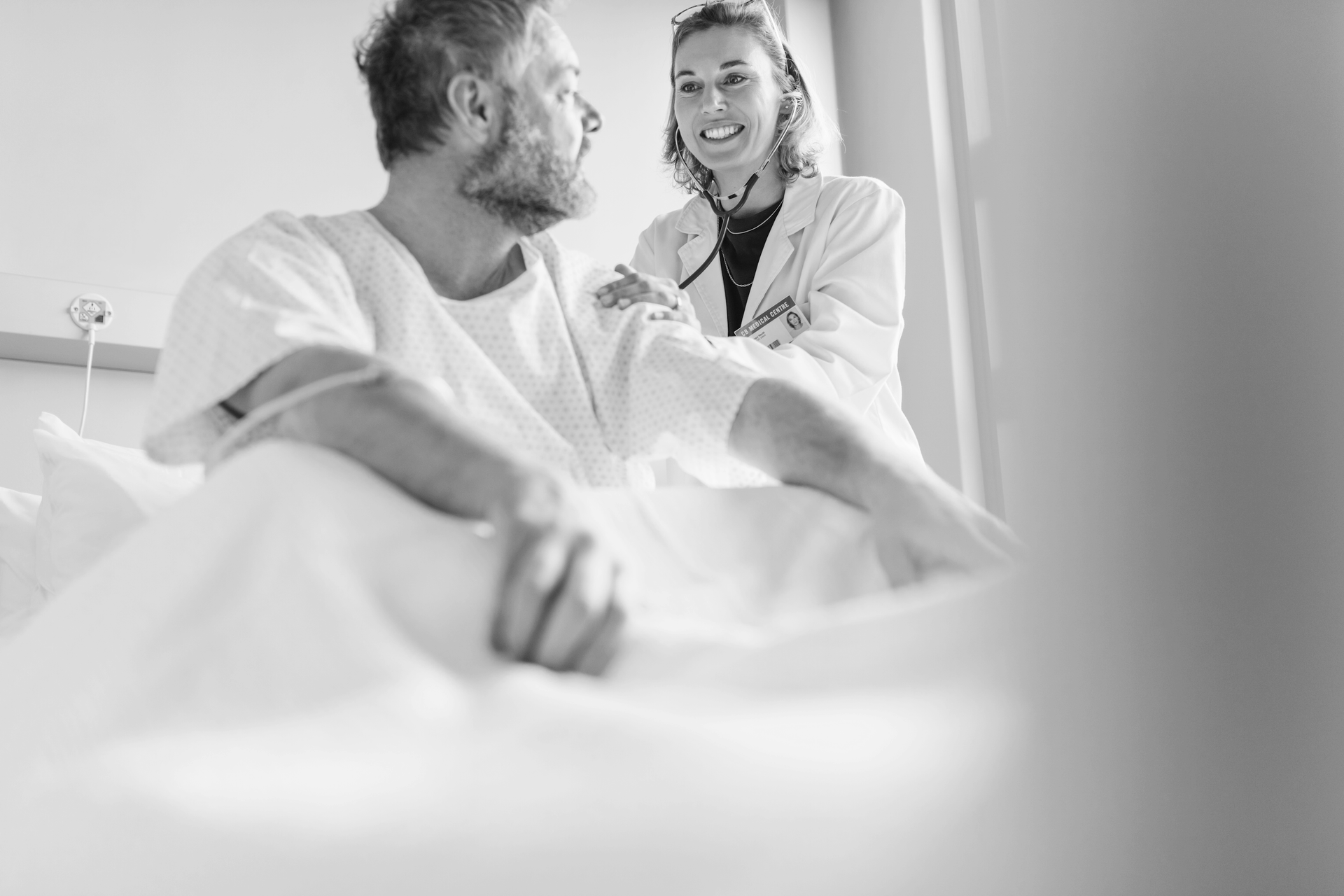 A doctor is talking to a patient in a hospital bed.