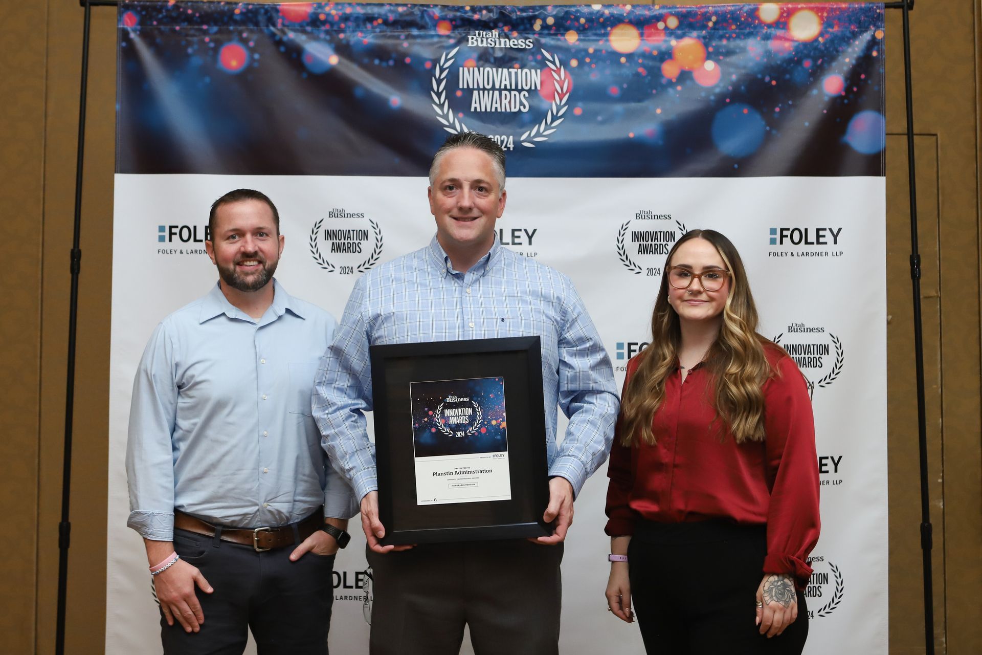 A group of people standing next to each other holding an award.