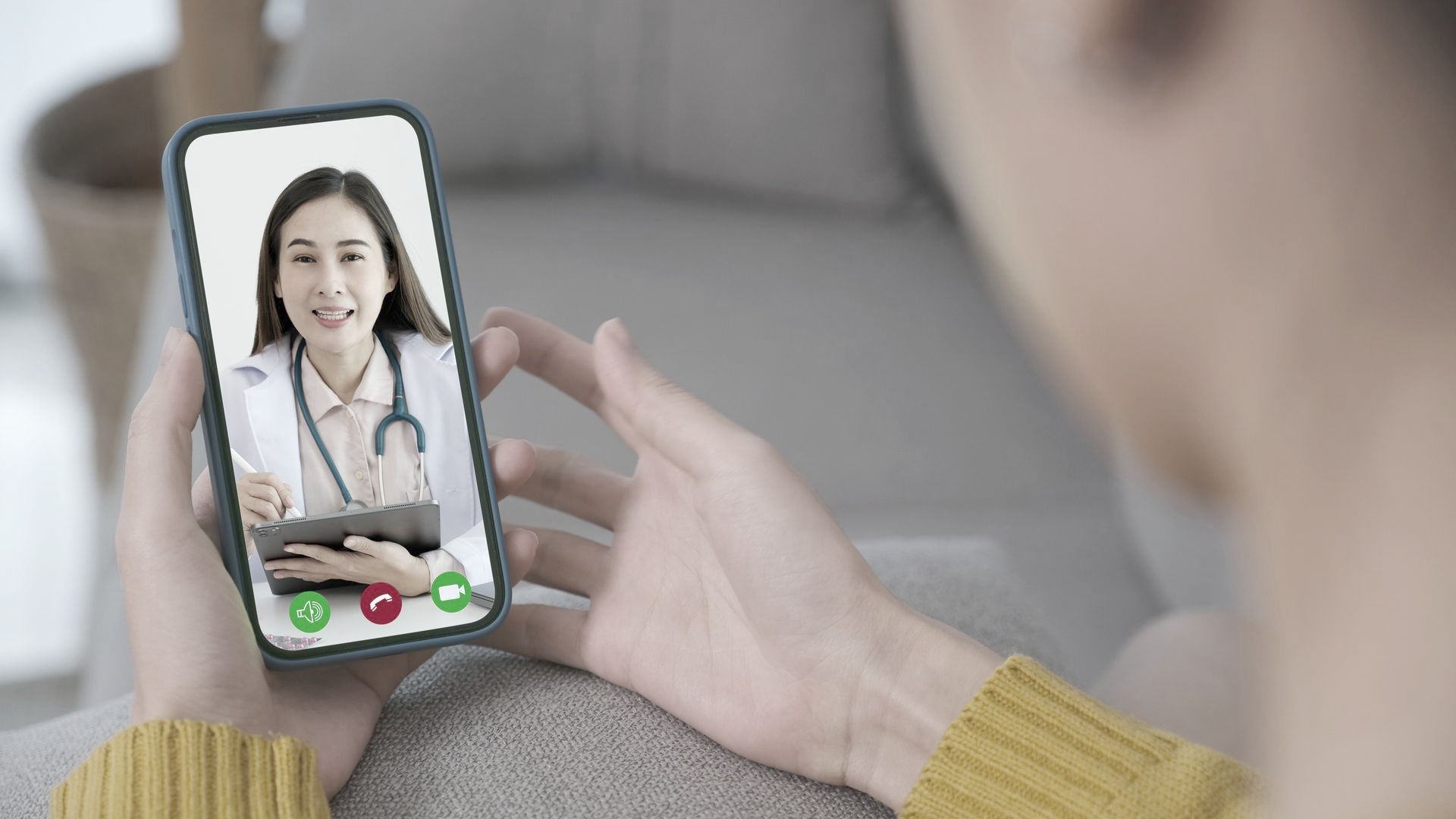 A woman is having a video call with a doctor on her cell phone.