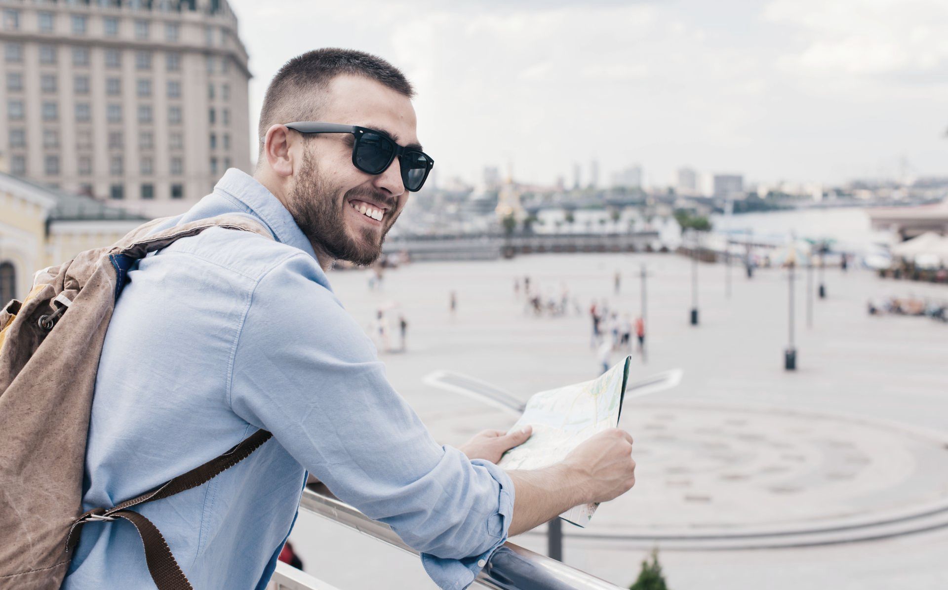 A man with a backpack is looking at a map.