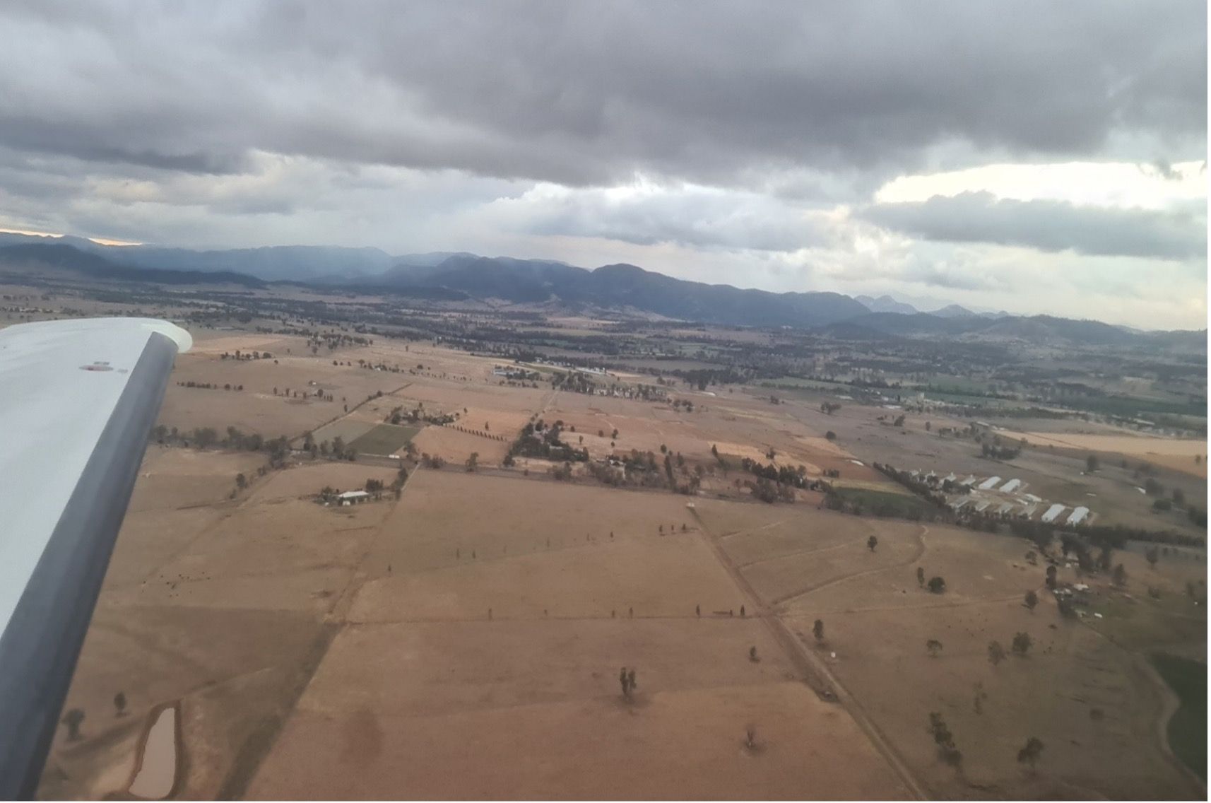 An aerial view of a desert landscape with mountains in the background