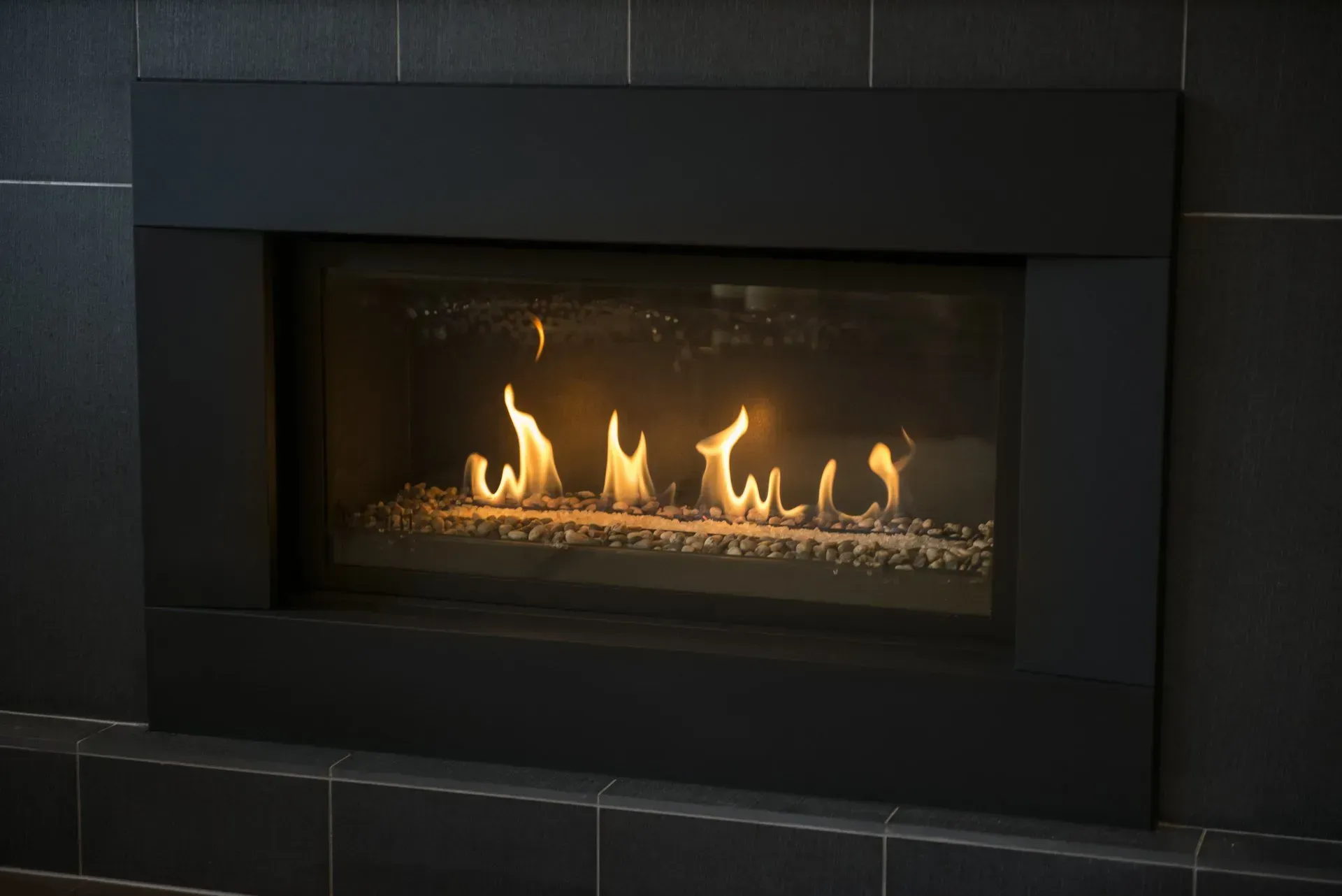 A fireplace with flames coming out of it and a black frame.