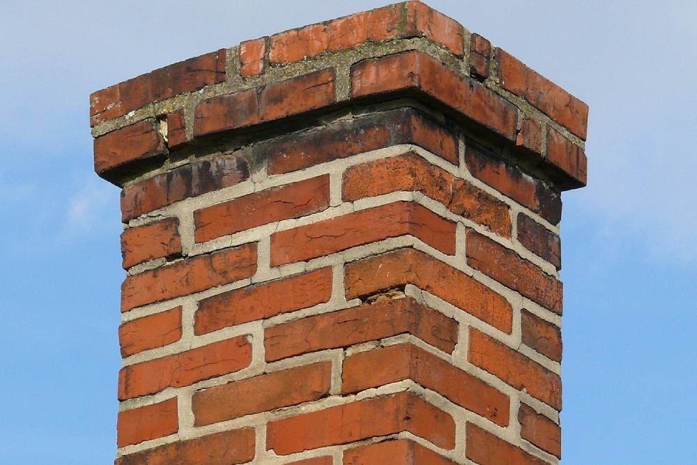 A brick chimney with a blue sky in the background