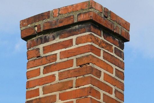 A brick chimney with a blue sky in the background