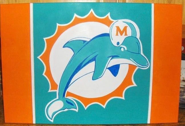 A picture of a dolphin with the letter m on its head