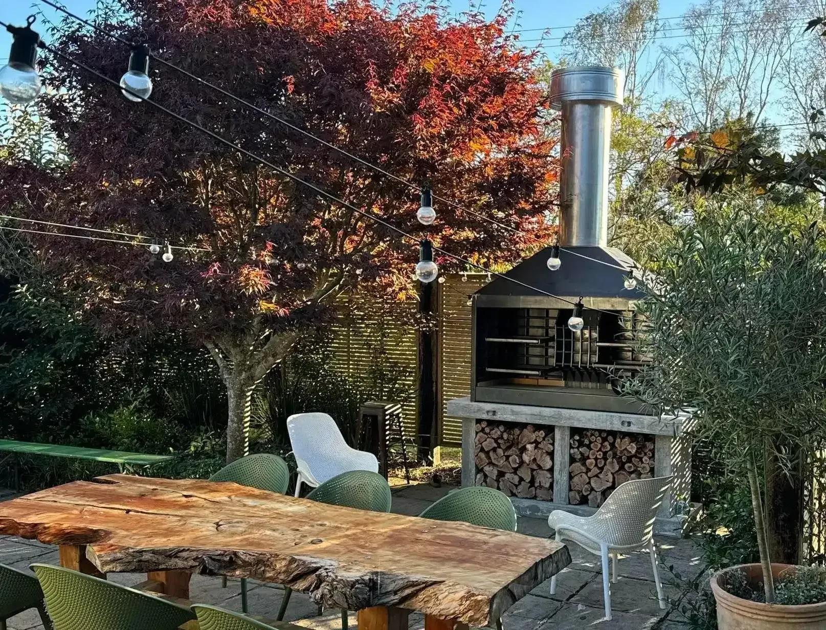 A patio with a table and chairs and a grill.