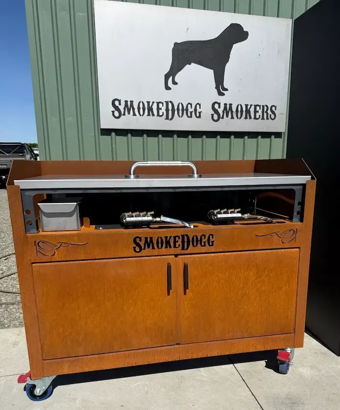 A black, rolling SmokeDogg outdoor Teppanyaki bbq griddle station with a stainless steel cooking surface and a storage shelf below.