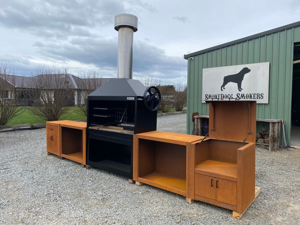 A row of wooden cabinets and a grill are sitting in front of a building.