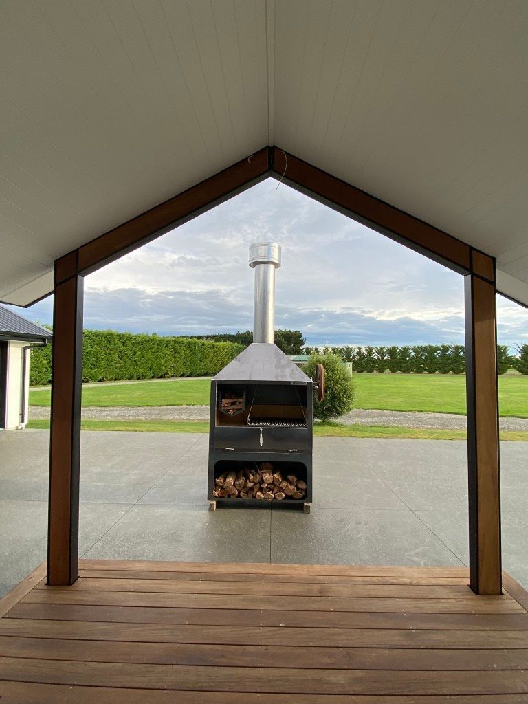 A wooden deck with a grill in the middle of it.