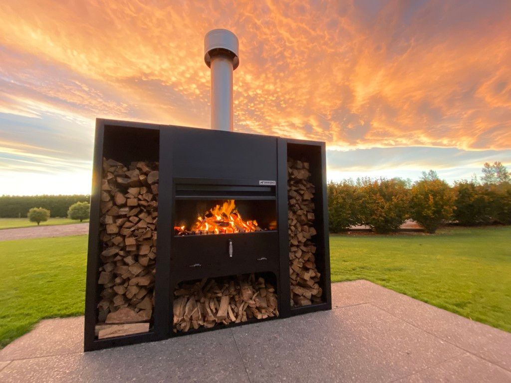 A fireplace with a chimney and a pile of wood in front of it.