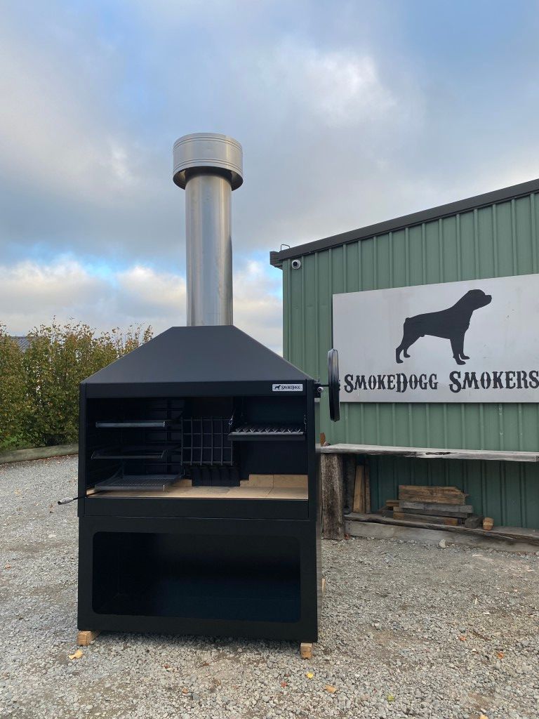 A large black grill is sitting in front of a building.