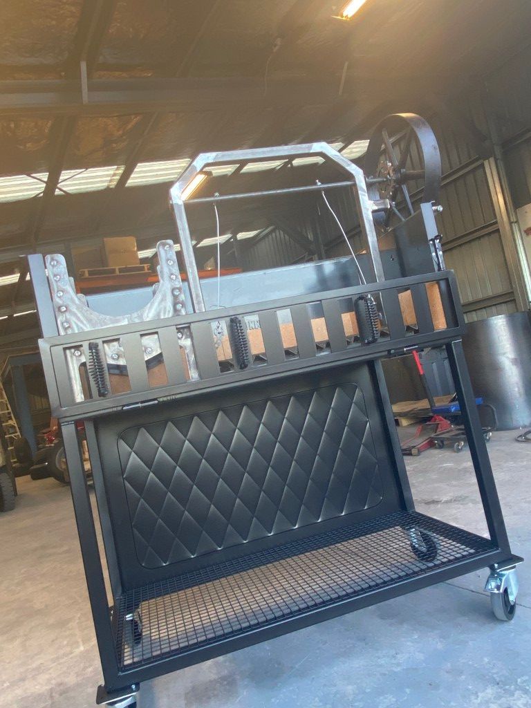 A black metal cart with wheels is sitting in a garage.
