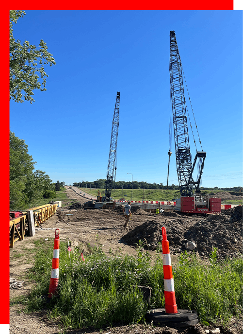 A construction site with a lot of cranes and cones.