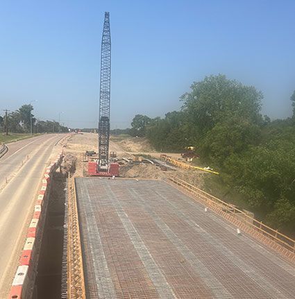 A large crane is sitting on top of a bridge under construction.