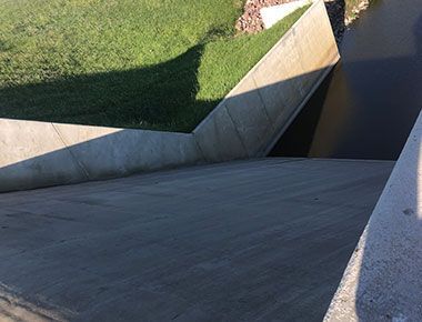 A concrete ramp leading up to a grassy area.