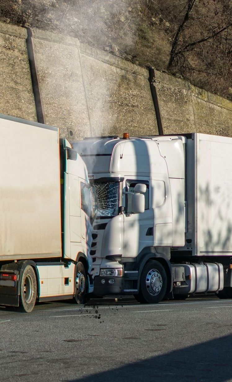 A truck with smoke coming out of it is parked next to another truck.