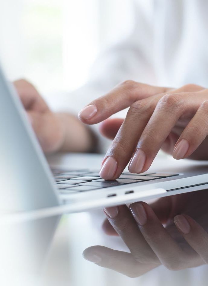A person is typing on a laptop computer.