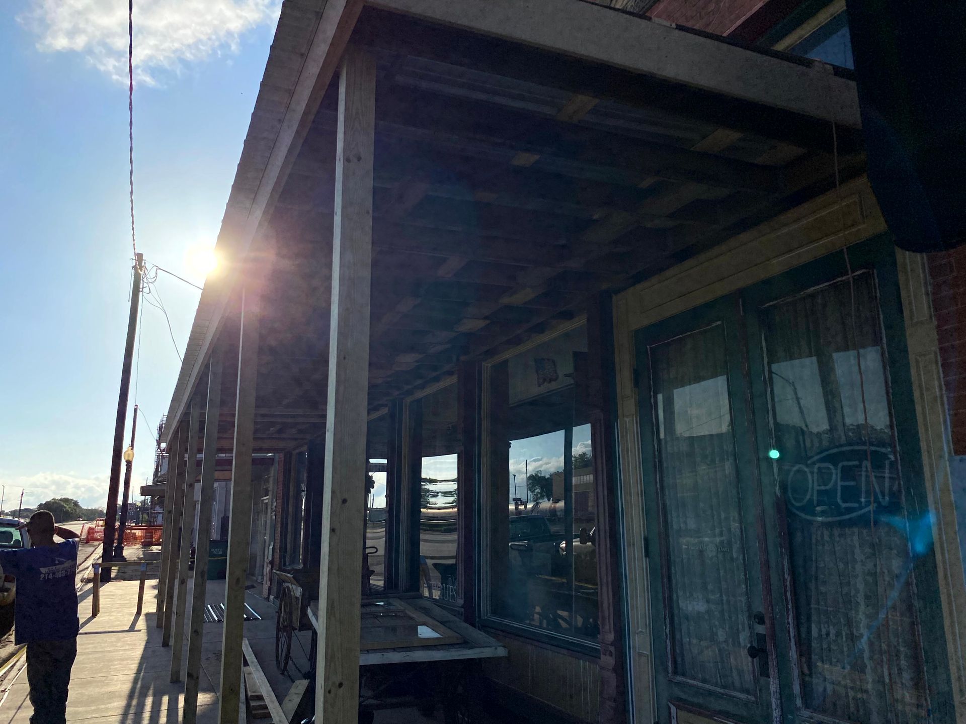 The sun is shining through the windows of a building being worked on by remodeling contractors.