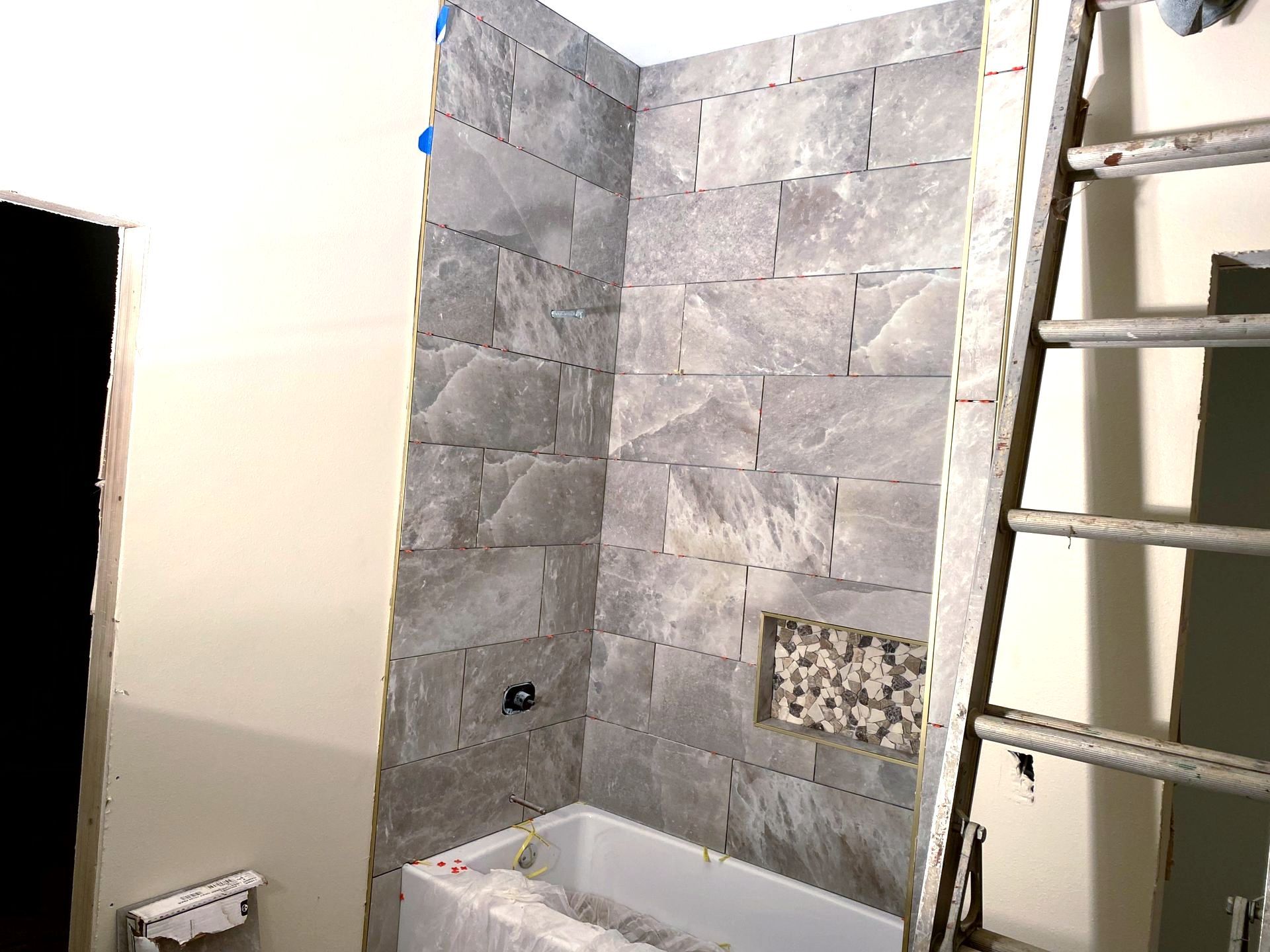 A bathroom under construction with a bathtub by remodeling contractors.