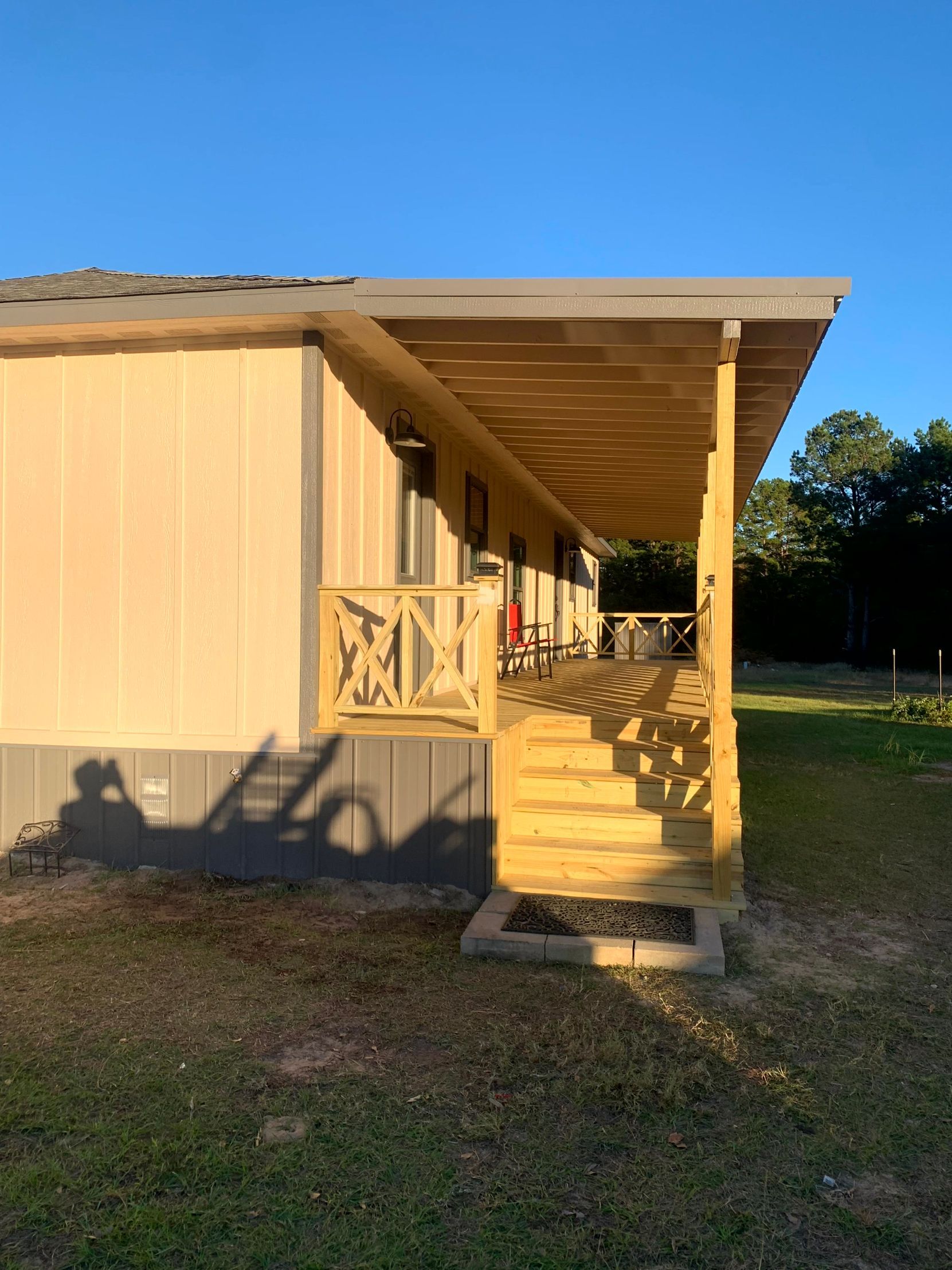 A mobile home with a porch and stairs on the side of it by remodeling contractors.