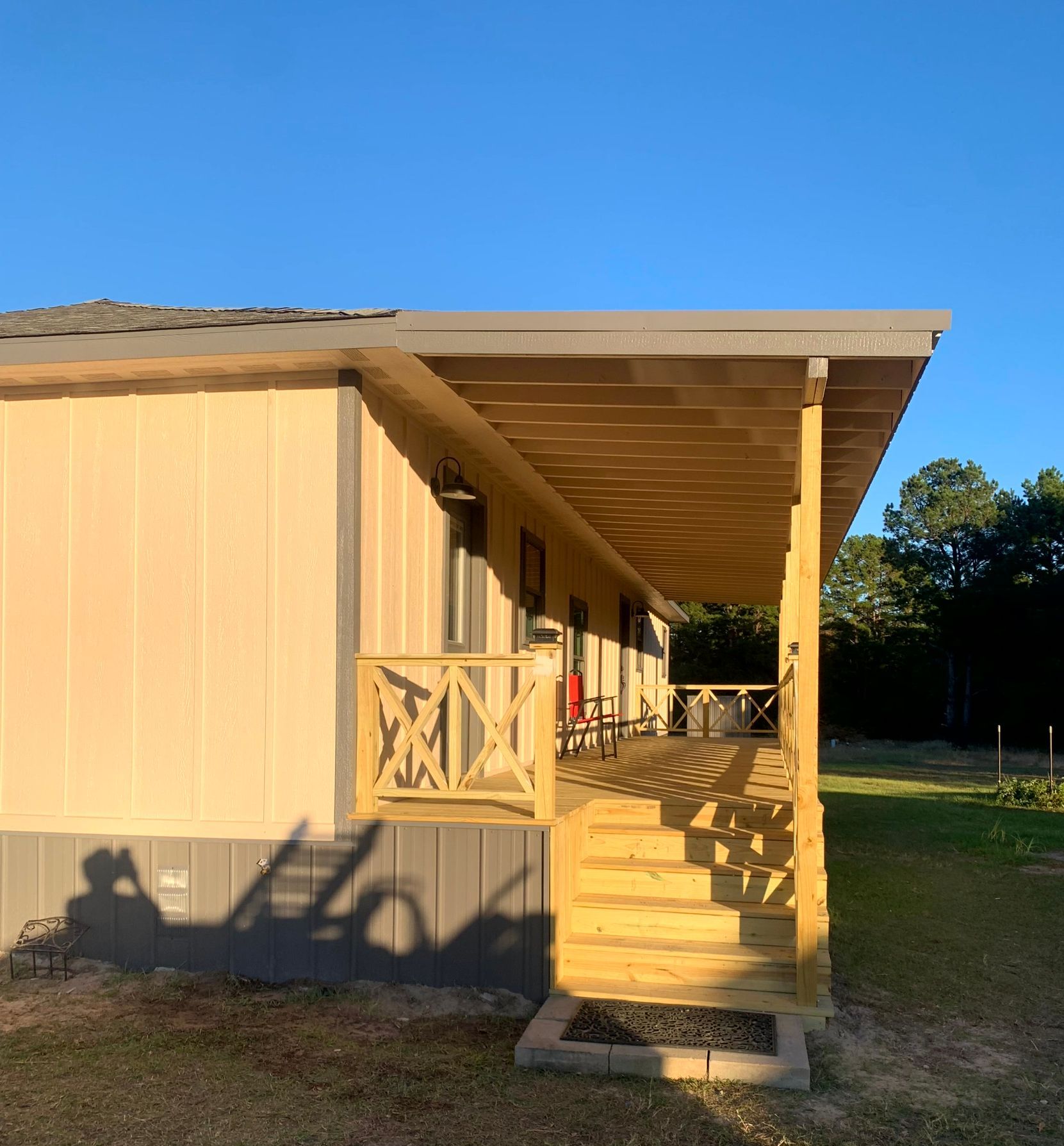 A mobile home with a porch and stairs made by remodeler.