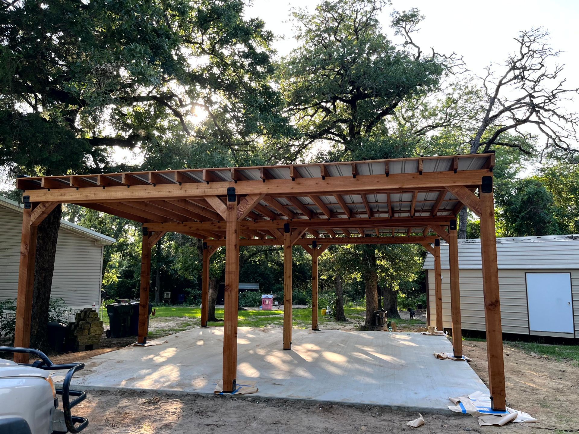 A carport is being built in the backyard of a house made by by renovating contractors.