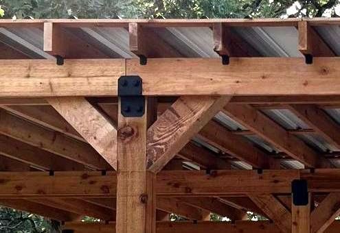A close up of a wooden structure with a metal roof constructed by remodeler.