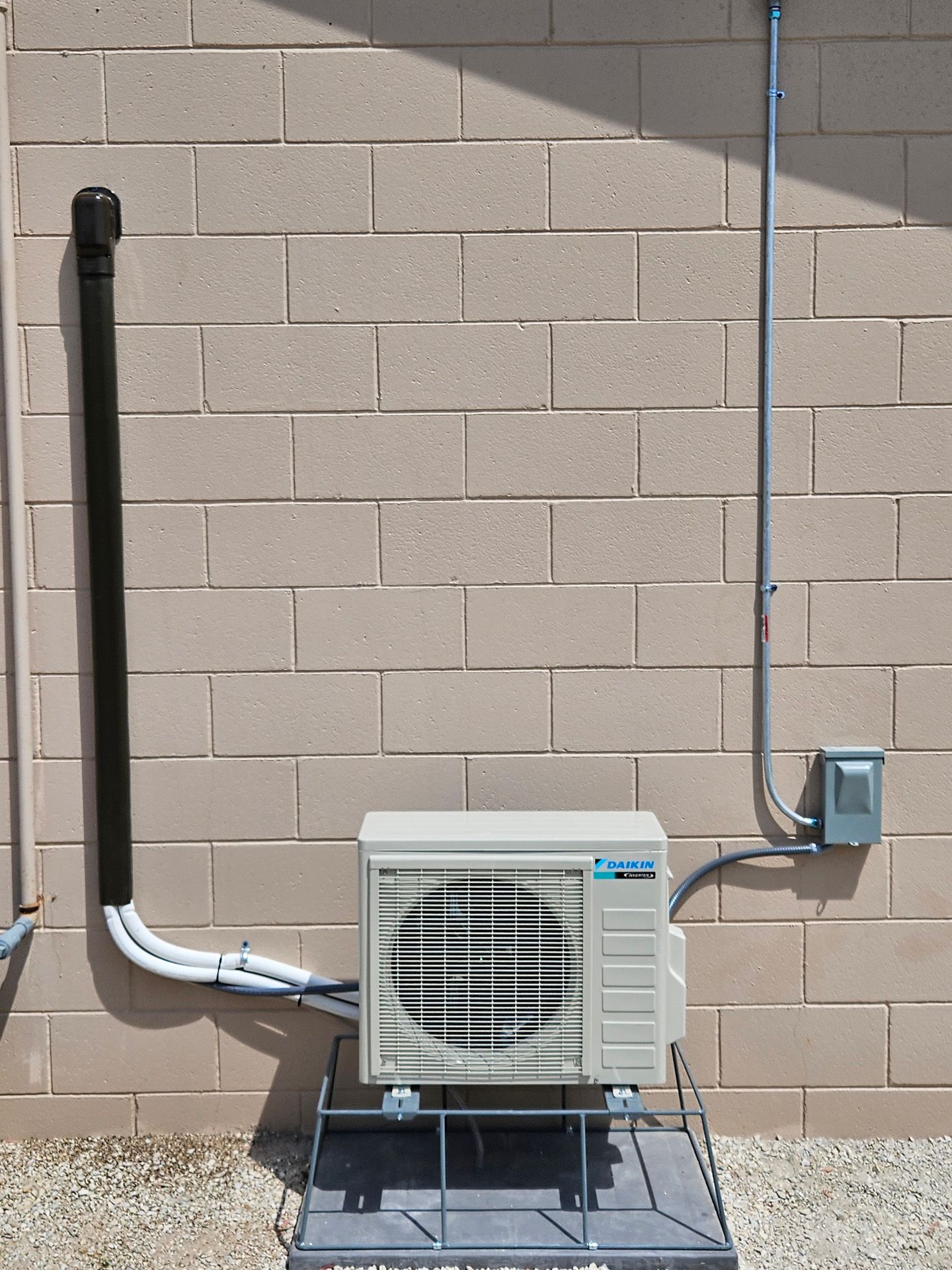 A panasonic air conditioner is attached to a brick wall