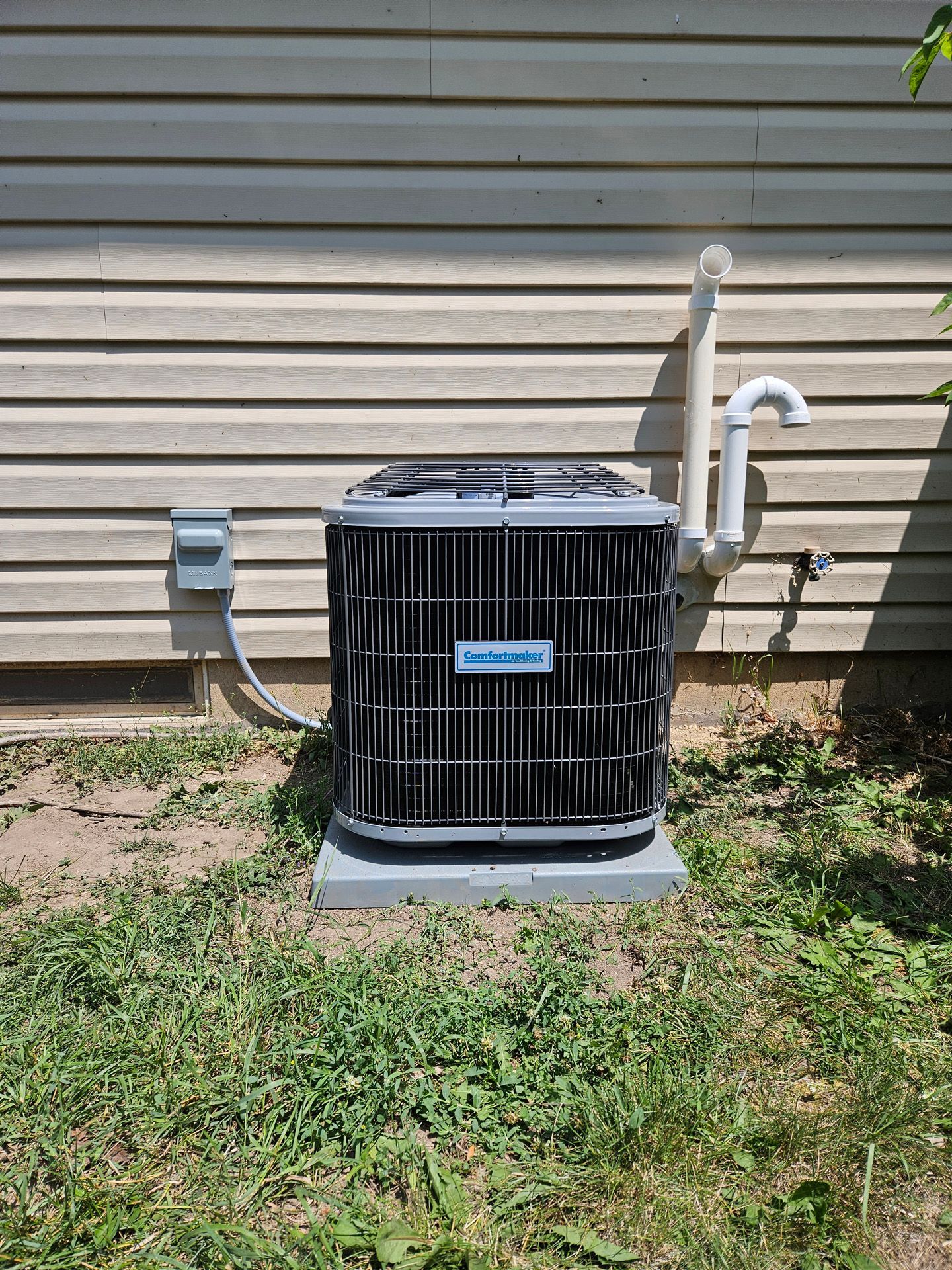 An air conditioner is sitting on the side of a house.
